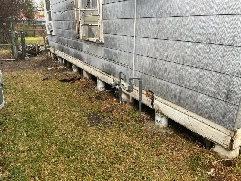 Finished perimeter of a raised house showing new sill board and evenly spaced concrete piers